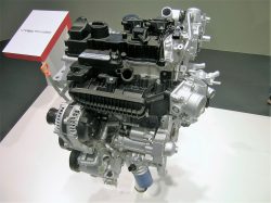 Her er den så, den nye 1-liters. Bemærk det usædvanlige arrangement på topdækslet. Det kunne ligne tilslutning til en V-motor, men den lille 3-benede er en rækkemotor.